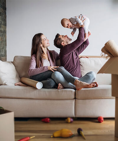 Modulo texto La familia crece - Pareja con su hijo haciendo la mudanza de su nueva casa felices