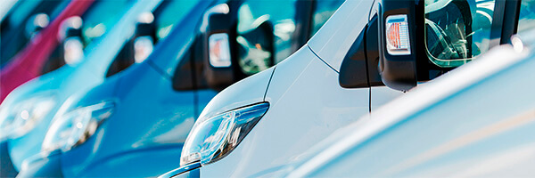 Seguro del Automovil para Empresas - Flota de furgonetas de empresa de diferentes colores aparcadas juntas entre ellas Seguro del Automovil para Empresas - Flota de furgonetas de empresa de diferentes colores aparcadas juntas entre ellas