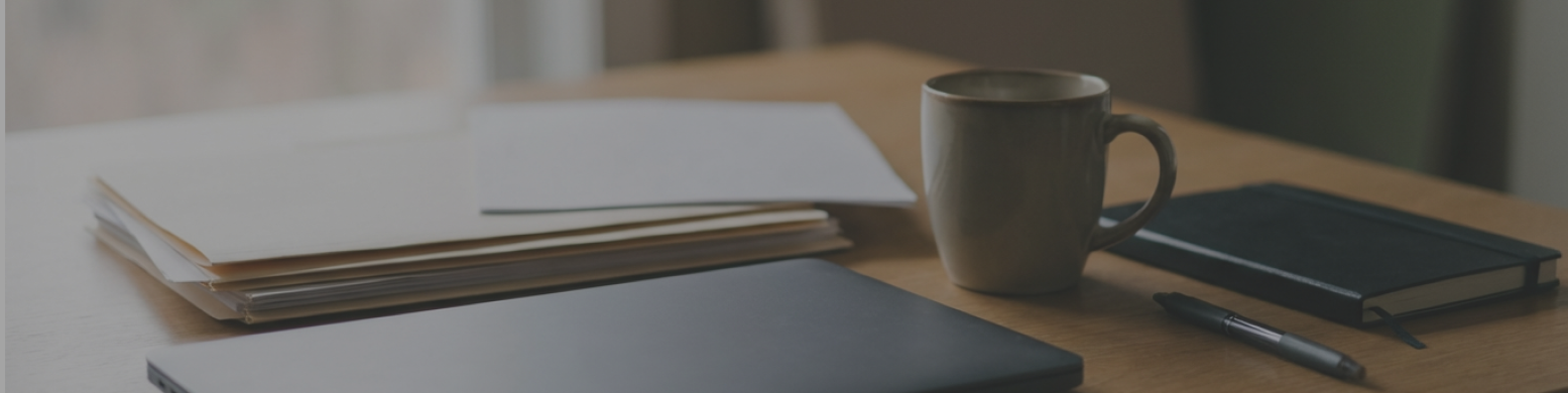 Mesa de trabajo con taza de café y cuadernos