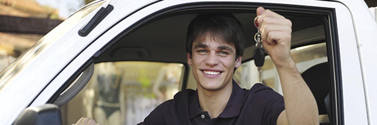 Préstamos Auto Negocio - Un chico feliz disfrutando de su coche nuevo